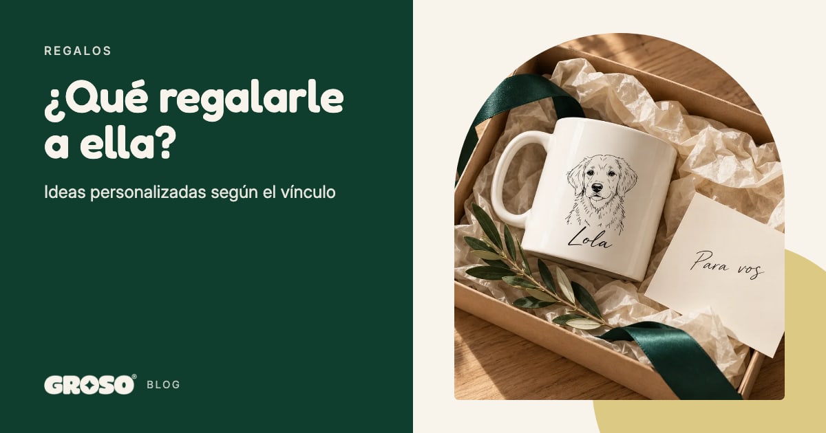 Una taza blanca con el retrato dibujado de un perro y el nombre Lola, en una caja de regalo con cinta verde y una tarjeta