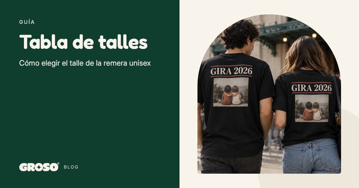 Una pareja de espaldas en la fila de un recital con remeras negras iguales que dicen Gira 2026 y llevan la foto de dos chicos